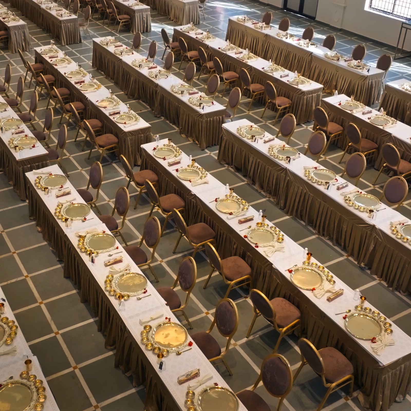 Traditional banquet dining tables set with gold service